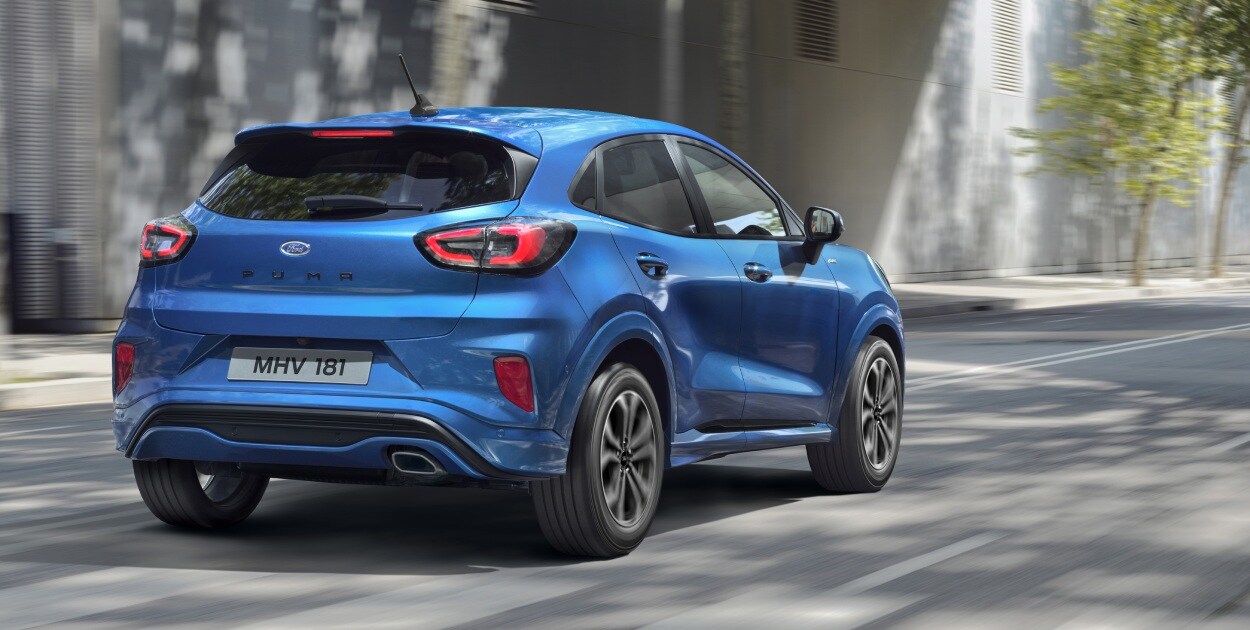 Blue 2020 Ford Puma driving through city rear three quarter view