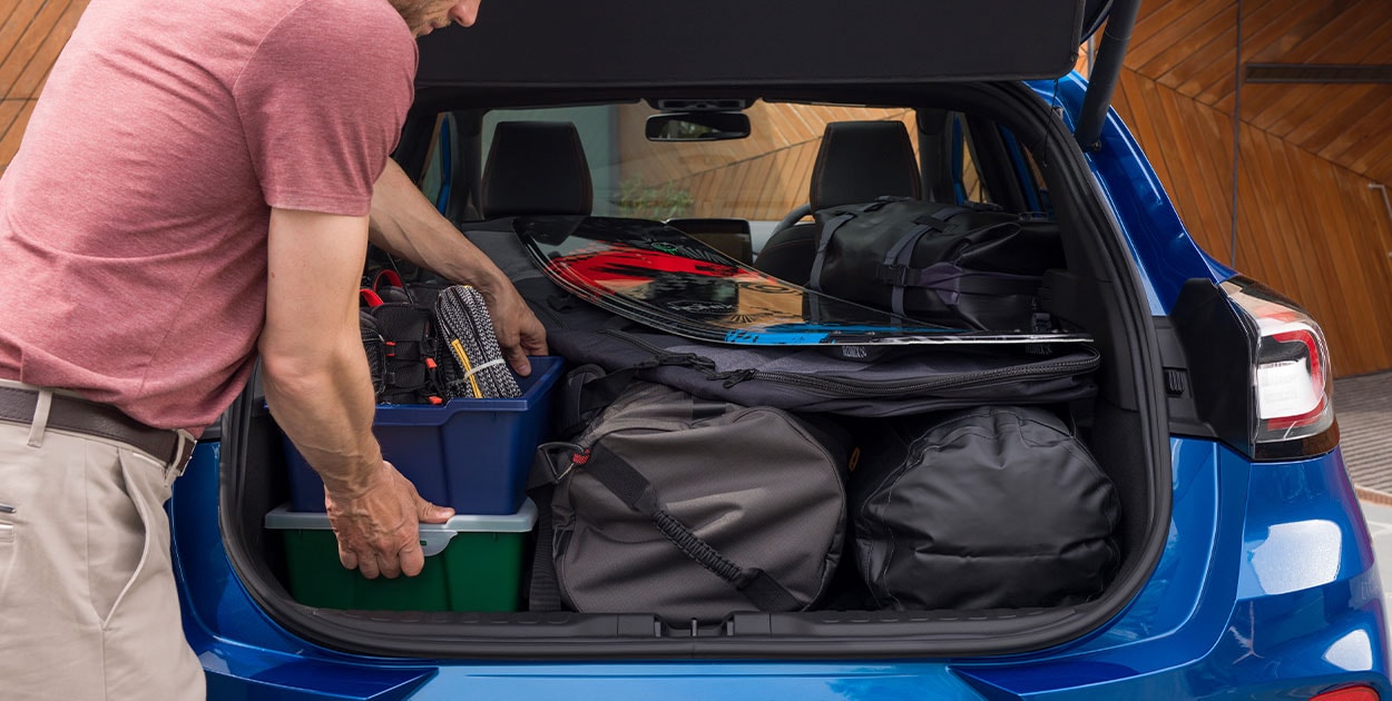 Man loading Ford Puma boot space with luggage