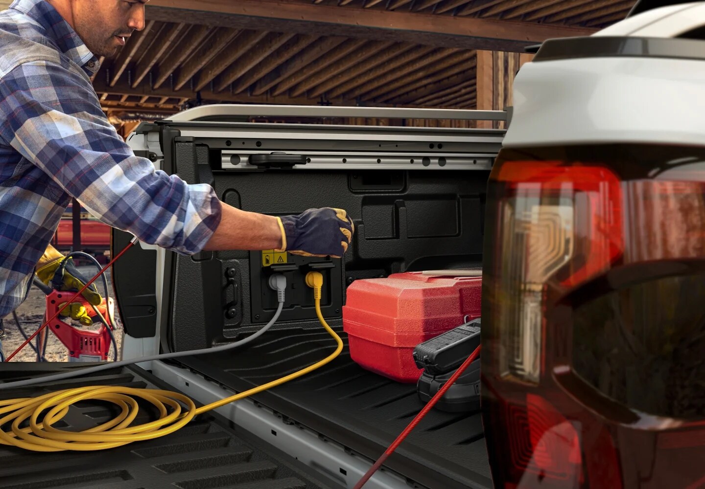A tradie charging powertools from the back of a Ford Ranger Hybrid.