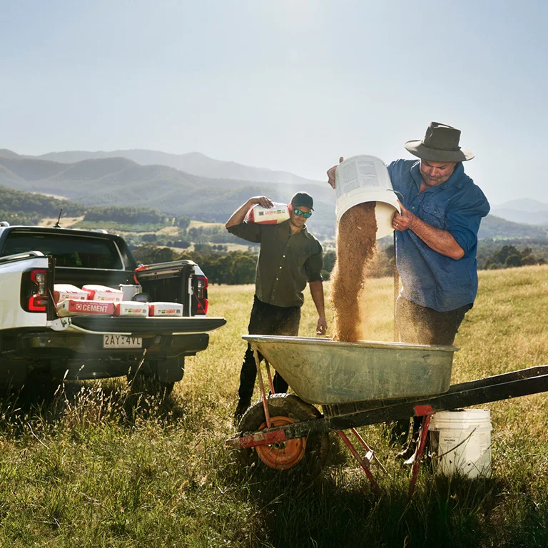 A Ford Mustang Mach-E® Rally SUV being driven in dirt with trees in the background