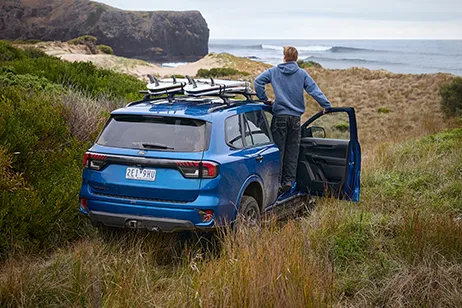 Blue SUV overlooking coastline