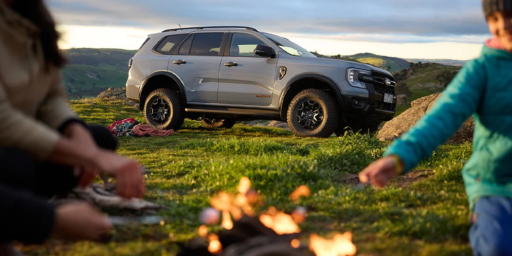 Off-road SUV beside campfire