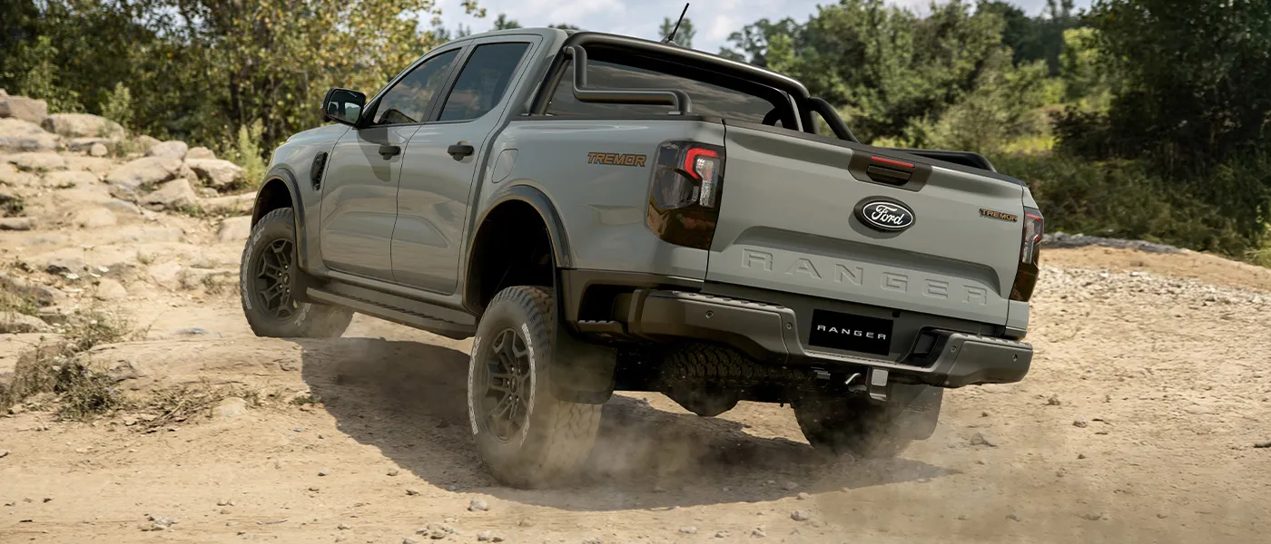 Ford Ranger Tremor grey driving off-road rear view.