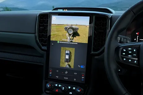 Dashboard interior view with black steering wheel and bright touchscreen display