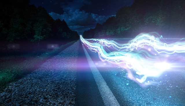 White vehicle driving through forest landscape overhead view