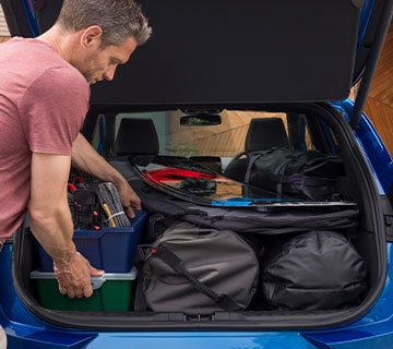 Man loading Ford Puma boot space with luggage